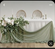 an image of a table setting with flowers and greenery on the tablecloths