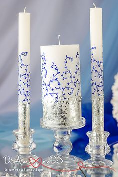 two candles sitting on top of each other in front of a blue and white background