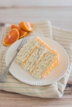 a piece of cake on a plate with orange slices and a fork next to it