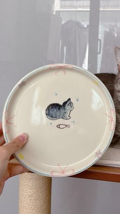 a person holding a plate with a cat on it