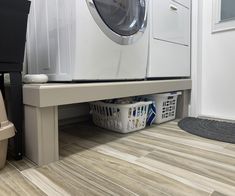 a washer and dryer sitting next to each other in a room with wood flooring