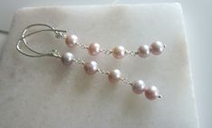 "These extra long, delicate pink freshwater pearl earrings are both classic and trendy. Dangling from a textured sterling silver modern ear wire, they will stay secure and move with every move you make. They are so versatile! They will look beautiful in any outfit, and can be worn at any time of the day or evening. As with all freshwater pearls, these show slight variations in shape and colour. This shows that they are genuine pearls, and adds to the charm of the earrings.   Show your trendy style and enjoy the compliments. Length:  3\" Pearl:     7mm nearly round" Delicate Pink Pearl Earrings, Delicate Pink Dangle Pearl Earrings, Elegant Pink Long Drop Earrings, Pink Dangle Pearl Earrings For Formal Occasions, Elegant Pink Linear Earrings As Gift, Elegant Pink Linear Drop Earrings, Elegant Pink Dangle Linear Earrings, Small Pearl Earrings, Extra Long Earrings