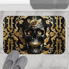 a pair of slippers sitting on top of a floor next to a black and gold skull