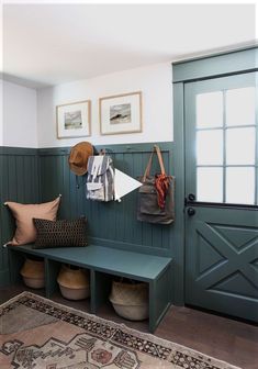 a green bench sitting next to a wooden door