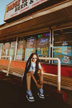 a woman sitting in front of a store