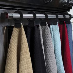 towels are hanging on the rack in front of an oven