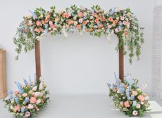 an arrangement of flowers and greenery is arranged on the stage for a wedding ceremony