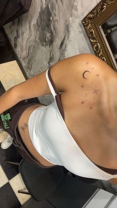 a woman is getting her back tattoo done