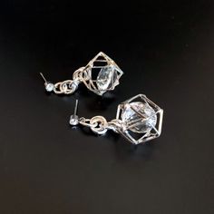 Unusual, sparkly diamond shaped crystals are captured in silver plated cages. I have joined them to the crystal, non allergenic, stainless steel posts with chain maille. Nice neutral earrings will go with anything. Makes a lovely gift. Here is a link to my whole shop: https://www.etsy.com/shop/designsbymalone RETURNS - BUY WITH CONFIDENCE Don't worry, I will refund or exchange an item up to 60 days. Makes gift giving easy! All my items will arrive in a gift box and/or a velvet or organza pouch. Party Earrings With Clear Metal, Clear Pierced Jewelry For Party, Diamond White Pierced Party Earrings, Party Crystal Earrings For Pierced Ears, Party Clear Crystal Earrings For Pierced Ears, Silver Crystal Dangle Earrings With Sparkling Stones, Silver Metal Crystal Earrings For Party, Silver Crystal Earrings For Party, Silver Single Crystal Earring For Party