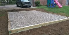 a car parked in front of a house next to a yard with gravel and rocks