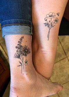 two women with matching tattoos on their legs, one has flowers and the other has butterflies