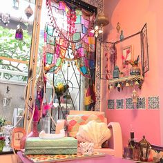 a living room filled with lots of furniture and decor on top of a pink wall