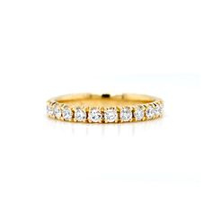 a yellow gold wedding band with five round diamonds on the inside and outside, set against a white background