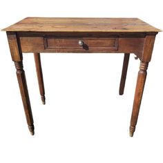 an old wooden table with two drawers on one side and three legs on the other