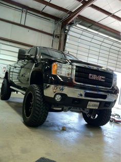 a large black truck parked in a garage