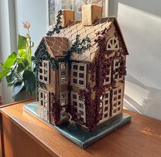 a gingerbread house made to look like it has ivy growing on the roof