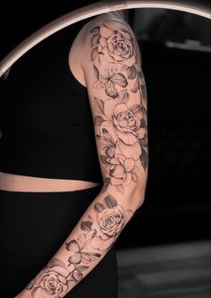 a woman's arm with flowers on it and a ring around her waist,