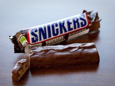 a bar of snickkers sitting on top of a wooden table