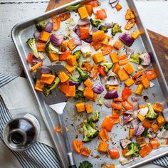 a pan filled with vegetables on top of a wooden table