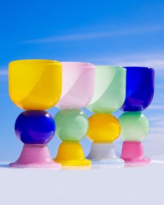 several different colored cups sitting on top of each other in front of a blue sky