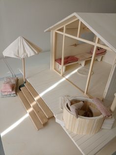 a doll house with furniture and accessories on the floor next to an umbrella, bed