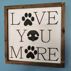 a sign that says love you more with paw prints