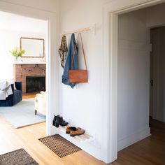 shoes are hanging on the wall next to a coat rack in a room with hardwood floors