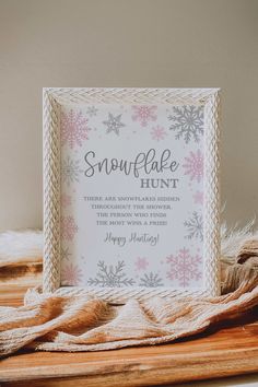 a snowflake hunt sign sitting on top of a wooden table next to a blanket