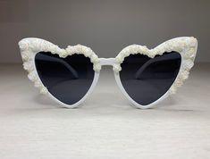 Heart-shaped cat's eye white sunglasses with custom design white roses with AB on the tip of the petals . Perfect for fashion/weddings or just everyday that you want to look white hot and sparkly. Frame: Acrylic Gems: Acrylic roses  UV: 400 Style: Vintage Designer Retro Cat Eye Sunglasses Elegant Summer Wedding Sunglasses, Elegant White Sunglasses For Wedding, Elegant White Wedding Sunglasses, White Sunglasses For Spring Gift, White Heart-shaped Sunglasses For Valentine's Day, Trendy White Sunglasses For Valentine's Day, White Heart-shaped Sunglasses For Summer, White Heart-shaped Sunglasses With Tinted Lenses, Heart-shaped White Sunglasses With Tinted Lenses