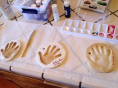 two handprints are placed on the counter with other crafting supplies around them