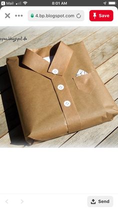 a brown shirt sitting on top of a wooden floor next to a box with buttons