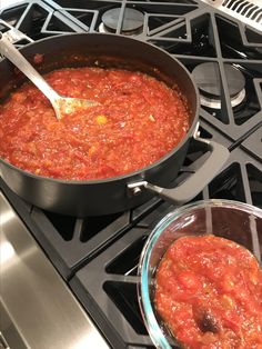 two pans filled with food sitting on top of an oven burner next to each other