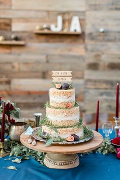 a wedding cake with flowers and candles on the top is surrounded by other desserts