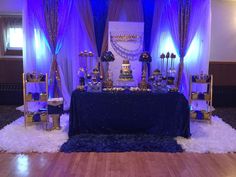 a table with blue and gold decorations on it at a wedding or other function venue