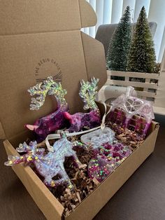 an open box filled with christmas decorations on top of a table