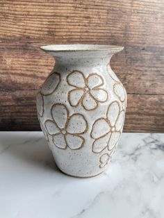 a white vase sitting on top of a marble counter