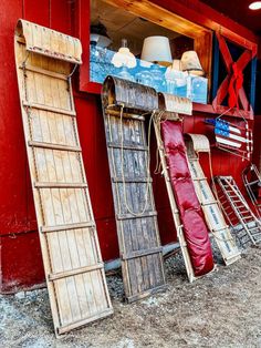 Vintage wooden sled toboggans leaned up against red antique store in Vermont.