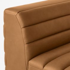 an upholstered brown leather chair with the seat folded back and arm rest down