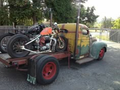 an old truck with a motorcycle on the back