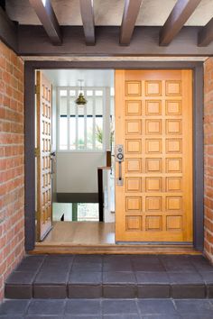 an open door to a room with brick walls and flooring on the outside side