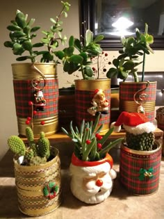 christmas decorations made out of tin cans with plants in them and santa hats on the top