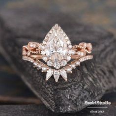 an engagement ring with a pear shaped diamond surrounded by small white and pink diamonds on top