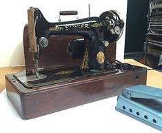 an old sewing machine sitting on top of a wooden table next to a blue object