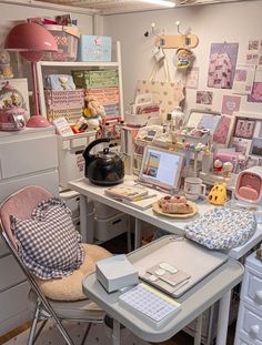 a desk with many items on it in a room filled with pictures and other things