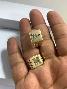 two gold rings in the palm of someone's hand