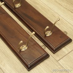 two pieces of wood with metal handles on the top and bottom, sitting on a wooden floor