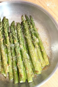 asparagus being cooked in a pan on a wooden table