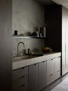 a kitchen with black walls and white counter tops, gray cupboards and a sink