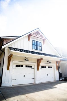 farmhouse Bomber LED gooseneck lights above dual garage doors, Barn Light Electric Outdoor Light Above Garage, Awning Above Garage Door, Farmhouse Exterior Lighting Garage, Pergola Over Garage Door Wood, Decorative Garage Overhang, Lights Above Garage Door, Garage Awnings Exterior, Modern Farmhouse Awning, White And Black House Exterior With Wood