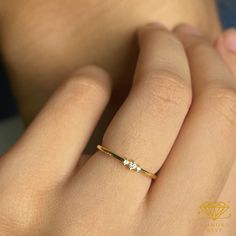 a woman's hand with a diamond ring on top of her finger and the other hand holding it